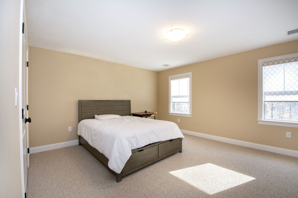 4 Kevin's Way, Unit 4 Scituate, MA 02066 - Photo 21 of 26 a bedroom with a bed lamp and a window