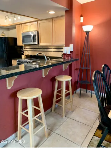 a kitchen with a dining table chairs and a refrigerator
