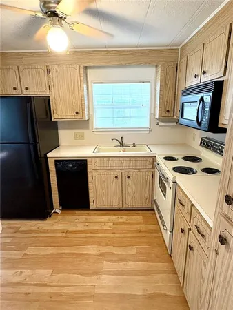 a spacious bathroom with a granite countertop sink a toilet a mirror and shower