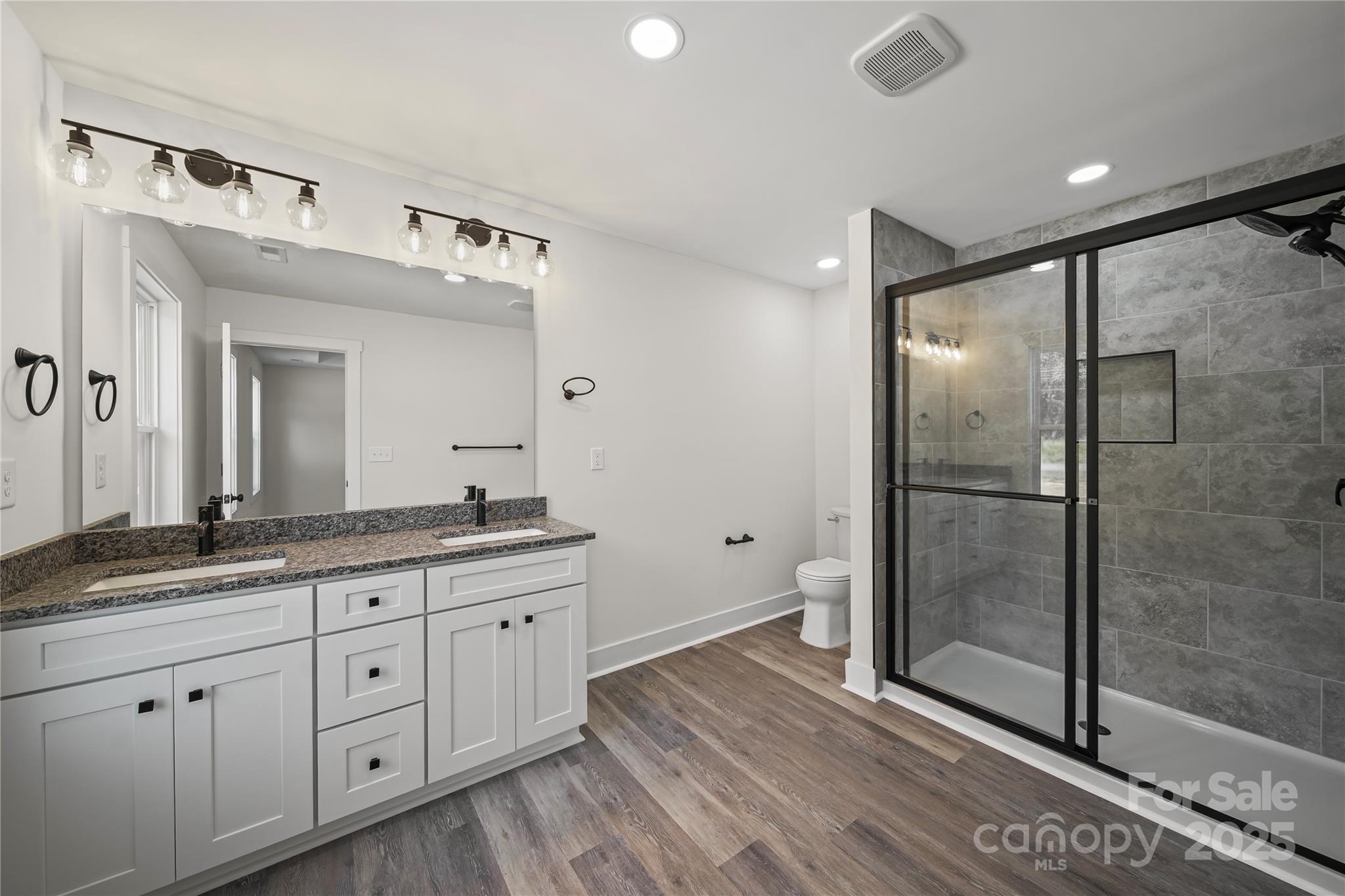 1308 Austin Chaney Road Wingate, NC 28174 - Photo 39 of 48 a spacious bathroom with a granite countertop sink mirror and shower
