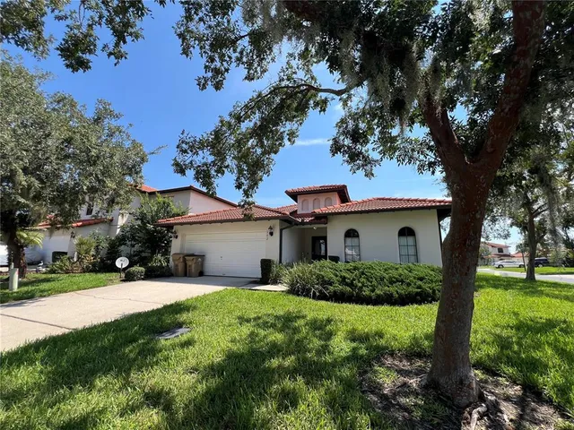 a white house that has a tree in front of it