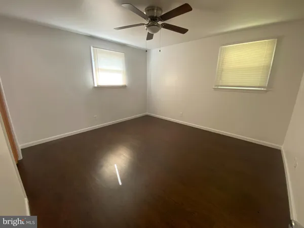 en empty room with windows and fan