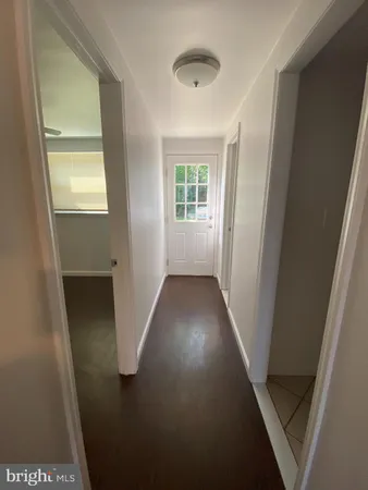 view of a hallway with wooden floor and a living room