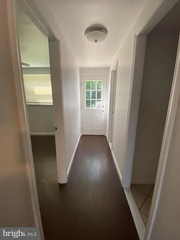 view of a hallway with wooden floor and a living room