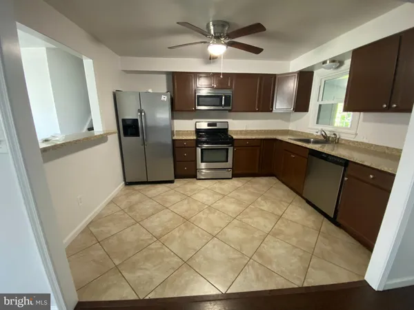 a kitchen with stainless steel appliances a stove a sink and a refrigerator