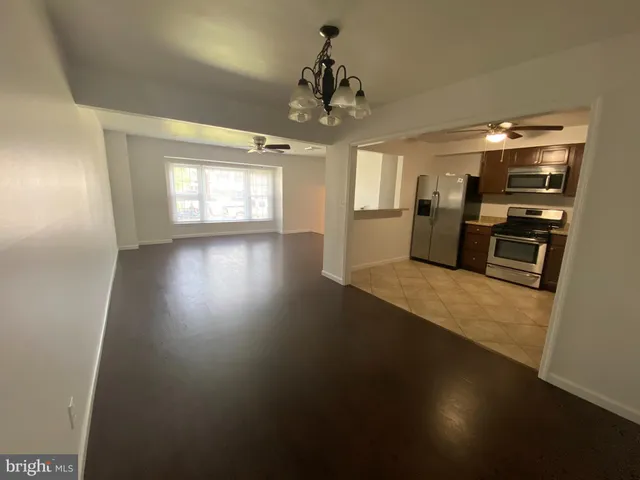 an empty room with wooden floor fireplace and windows