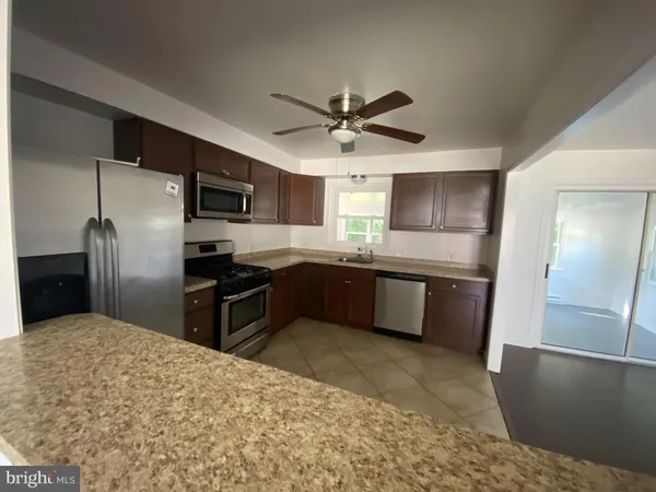 a kitchen with stainless steel appliances kitchen island granite countertop a refrigerator a sink a stove a microwave oven with cabinets