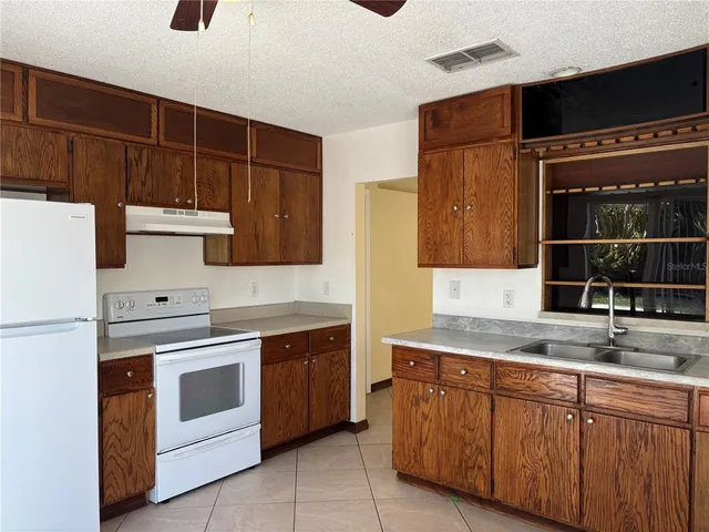 a kitchen with stainless steel appliances granite countertop a sink and a stove