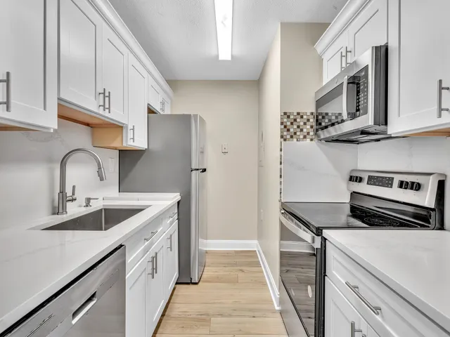 a kitchen with stainless steel appliances granite countertop a sink and a stove
