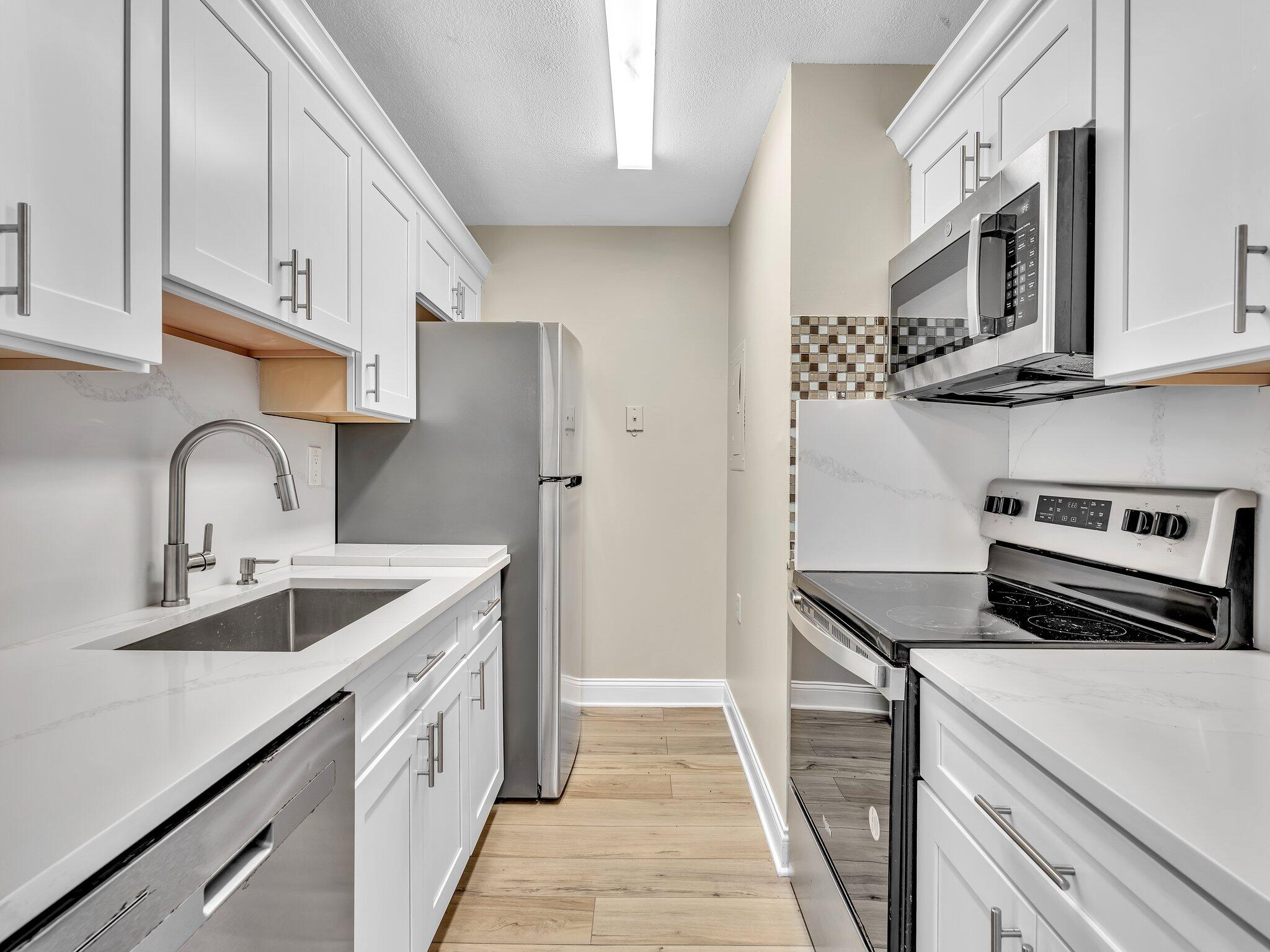a kitchen with stainless steel appliances granite countertop a sink and a stove