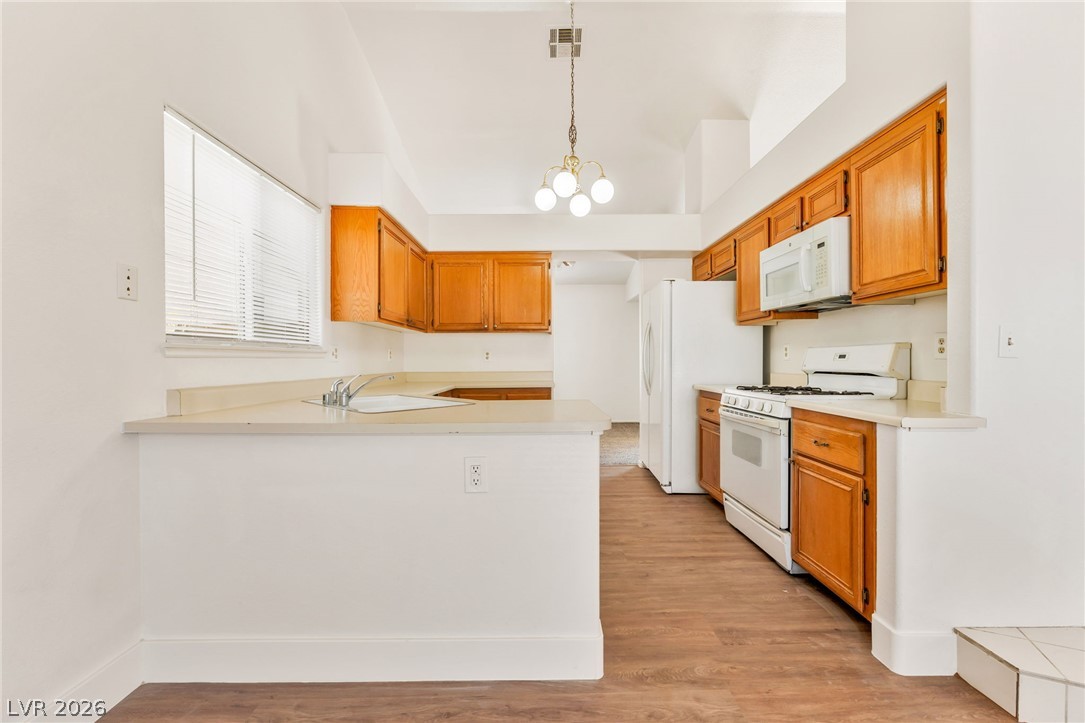 4904 Spring Falls Way North Las Vegas, NV 89031 - Photo 9 of 24 A well-lit kitchen with classic wood cabinetry and a functional layout awaits culinary creativity.