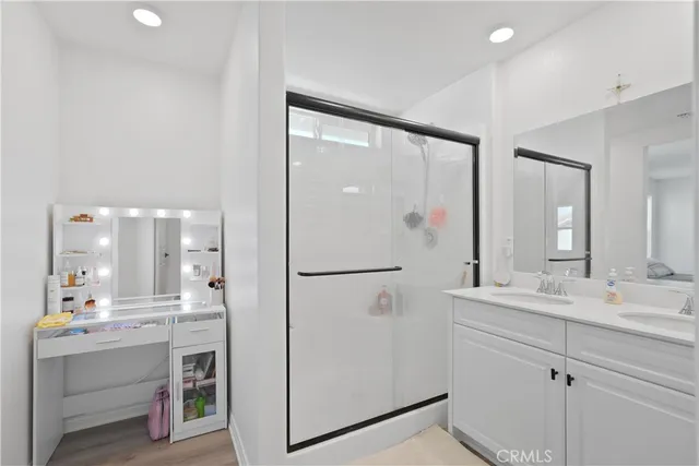 a bathroom with a double vanity sink mirror and shower