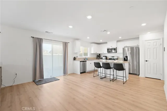 a open kitchen with white cabinets and stainless steel appliances