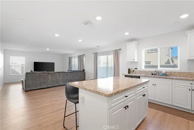 a large kitchen with kitchen island a sink and a refrigerator