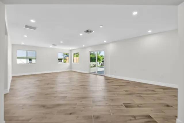 a view of empty room with wooden floor