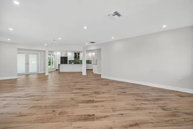 a view of empty room with wooden floor