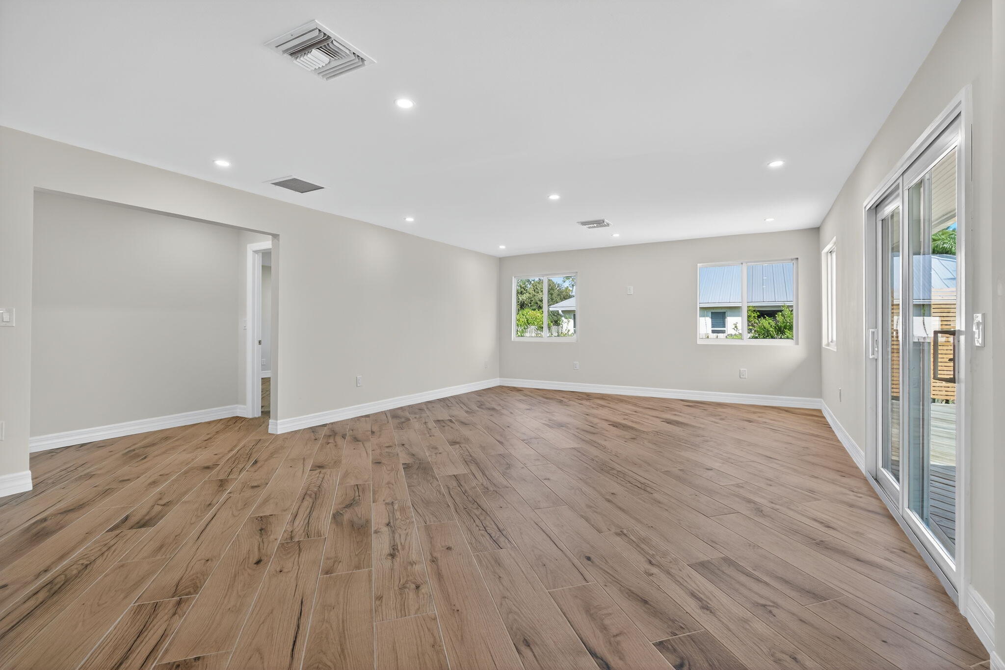 5273 Southeast Tall Pines Way Stuart, FL 34997 - Photo 18 of 62 an empty room with wooden floor and windows