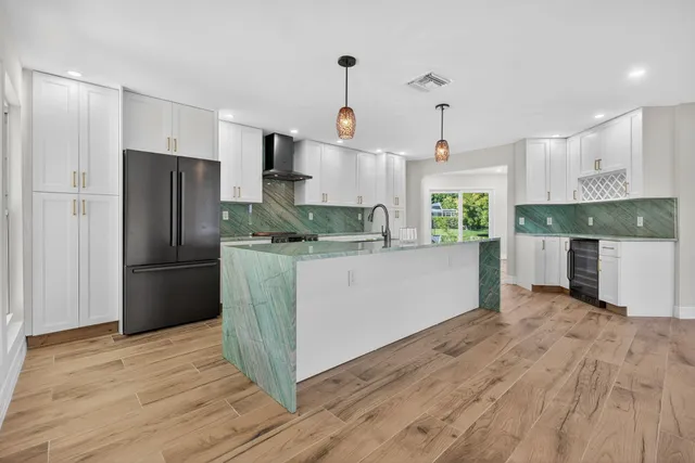 a kitchen with stainless steel appliances granite countertop a sink a stove and a wooden floors
