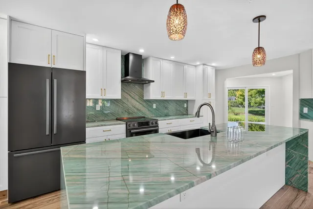 a kitchen with stainless steel appliances granite countertop a sink stove and refrigerator