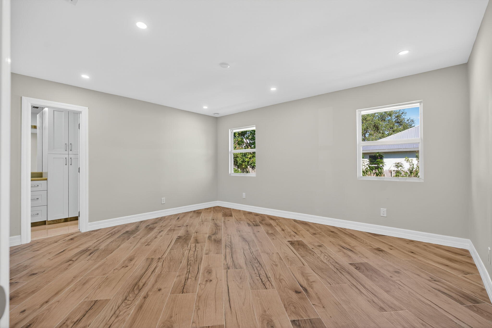 5273 Southeast Tall Pines Way Stuart, FL 34997 - Photo 28 of 62 an empty room with wooden floor and windows