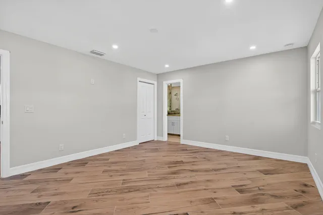 a view of an empty room with wooden floor