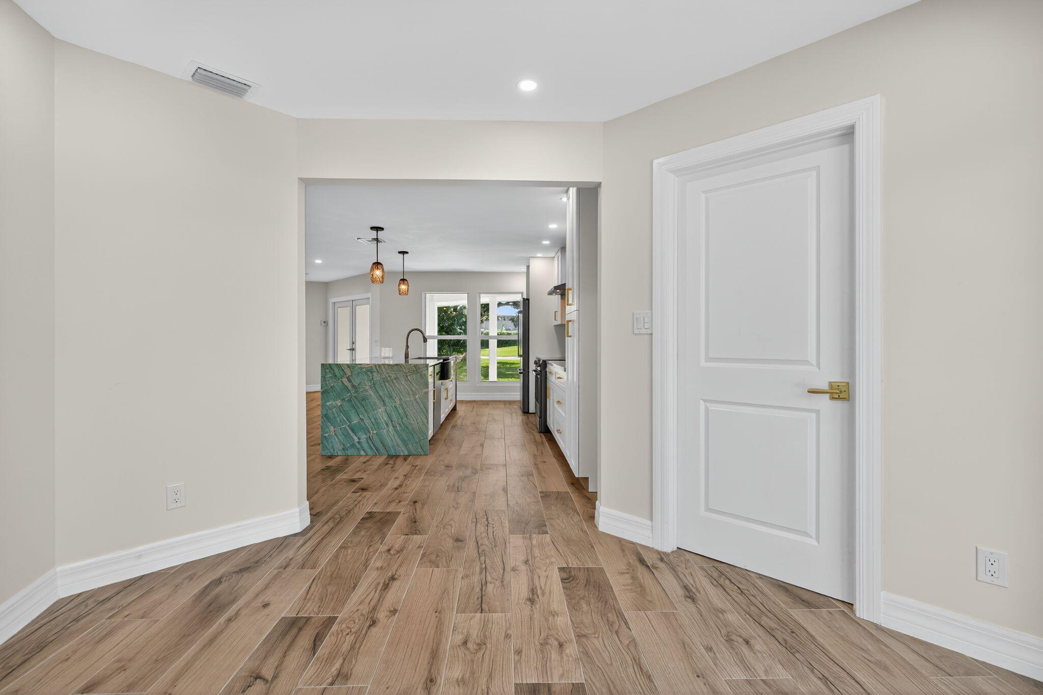 5273 Southeast Tall Pines Way Stuart, FL 34997 - Photo 9 of 62 a view of a hallway with wooden floor and a bathroom