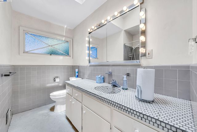 a bathroom with a toilet a sink and mirror