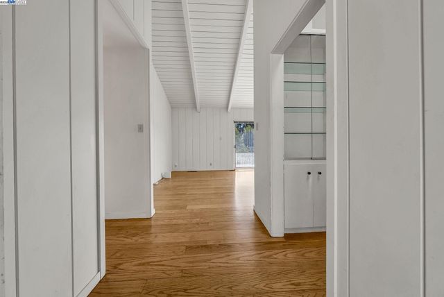 a view of empty room with wooden floor and cabinet