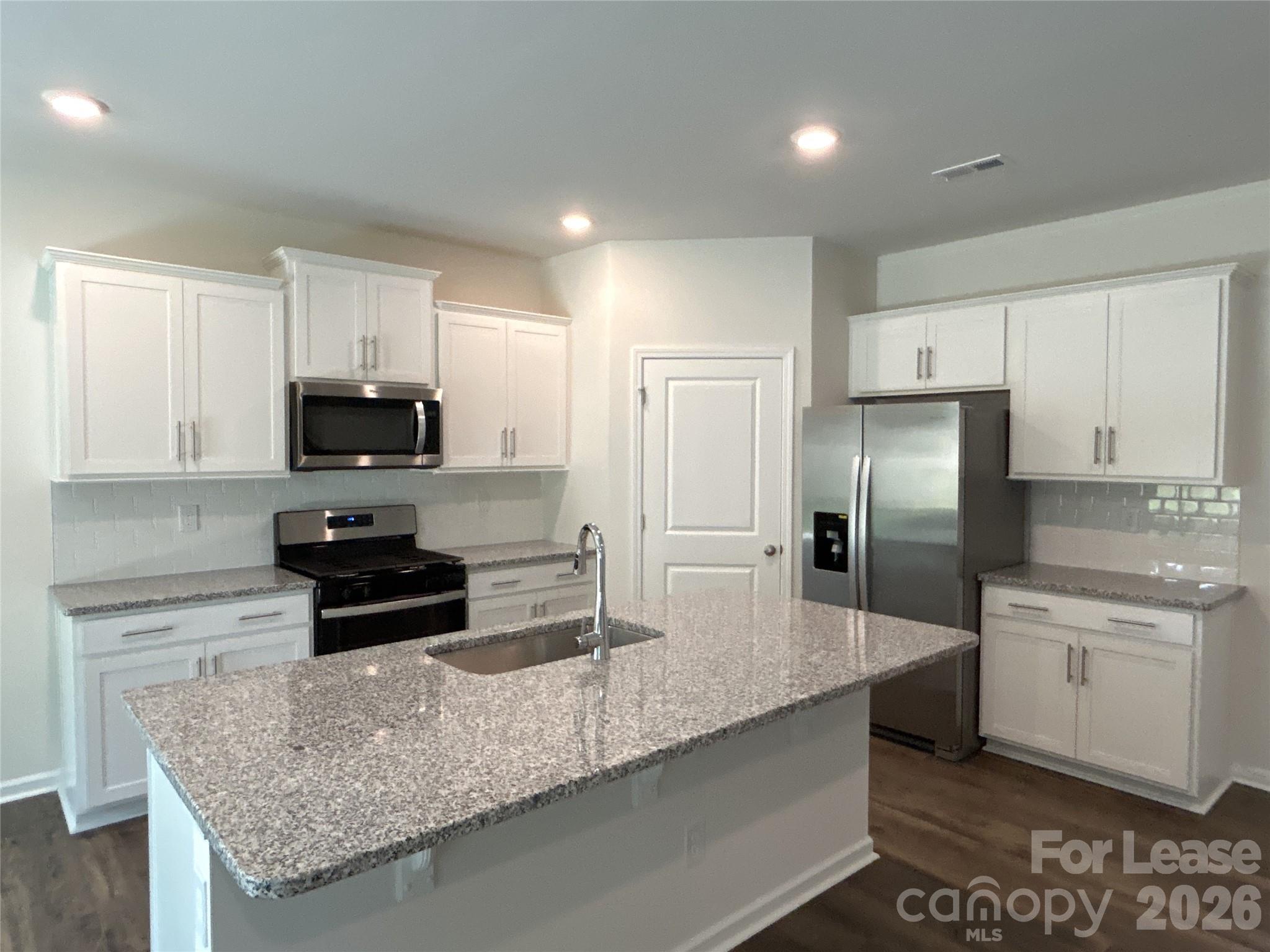 1920 Vanderlyn Street Monroe, NC 28112 - Photo 5 of 24 a kitchen with stainless steel appliances granite countertop a sink a stove and a refrigerator