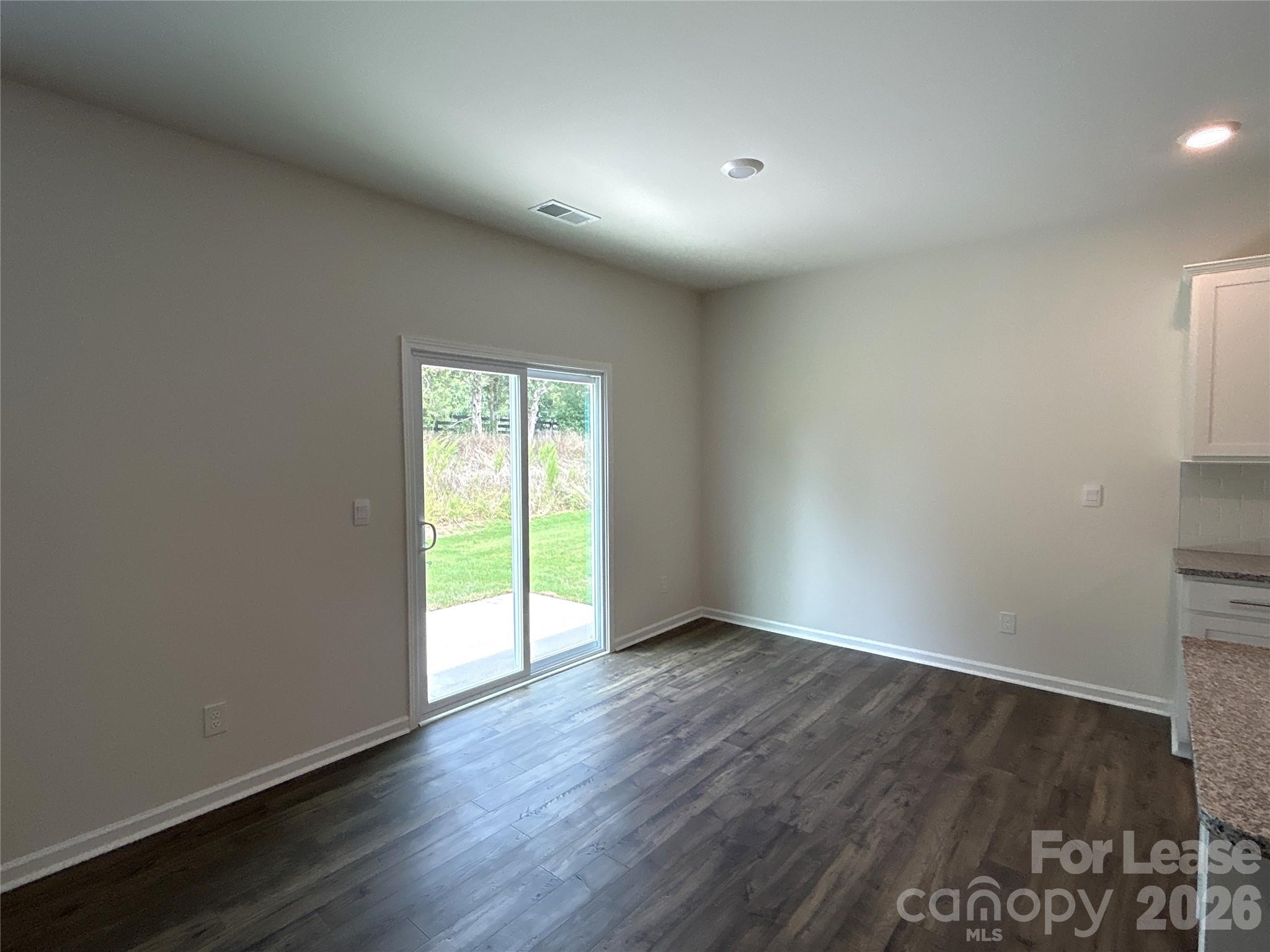 1920 Vanderlyn Street Monroe, NC 28112 - Photo 9 of 24 an empty room with wooden floor and windows