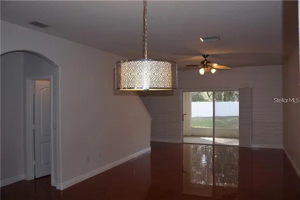 a view of an empty room with window wooden floor and cabinet