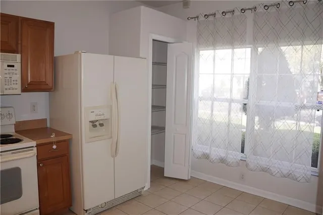 a view of a kitchen with refrigerator and window