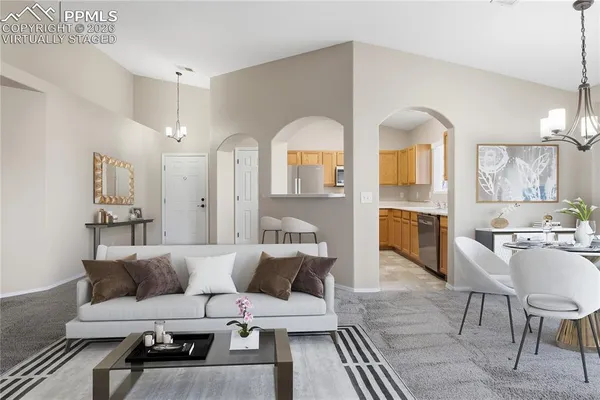 a living room with furniture white walls and kitchen view