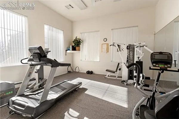 a room with gym equipment and a view of living room