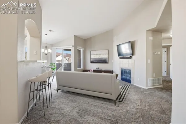 a living room with furniture a flat screen tv and a large window