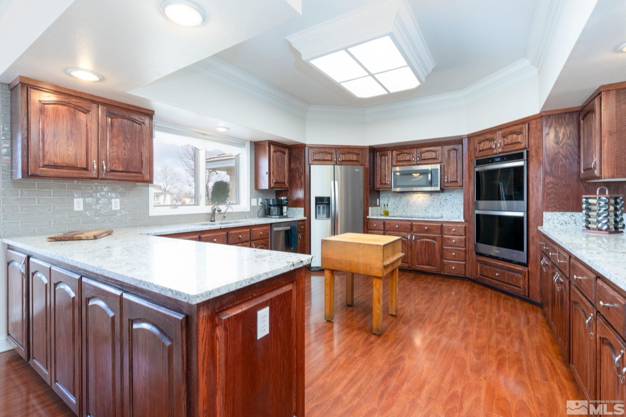 615 Carson River Drive Fallon, NV 89406 - Photo 11 of 40 a kitchen with stainless steel appliances wooden floor dining table and chairs