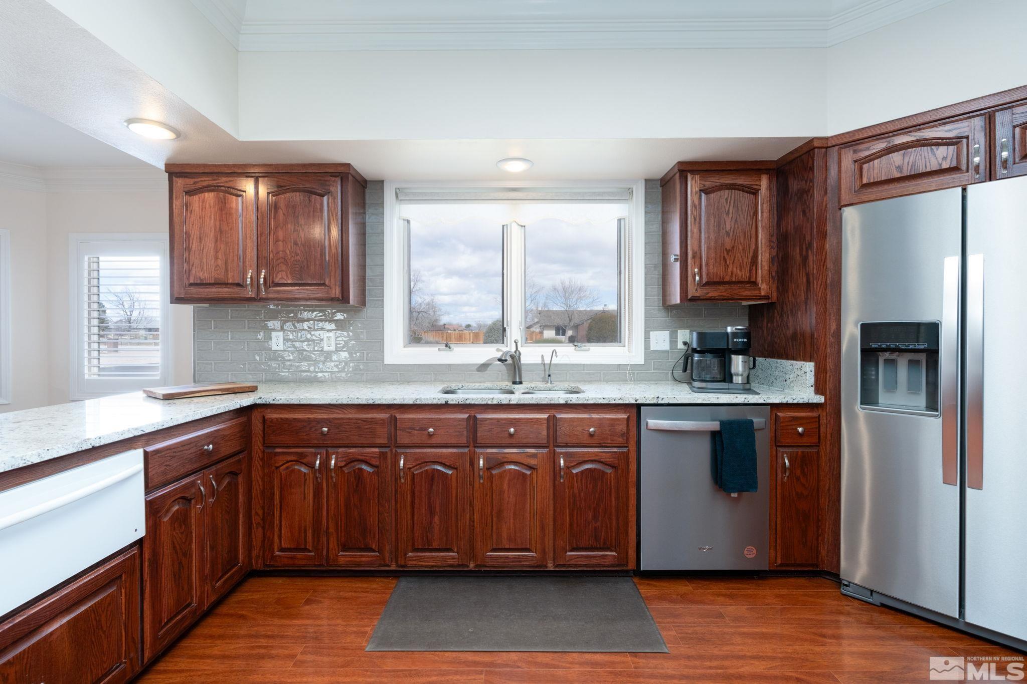 615 Carson River Drive Fallon, NV 89406 - Photo 13 of 40 a kitchen with stainless steel appliances granite countertop a refrigerator a sink dishwasher a stove with wooden cabinets and floor