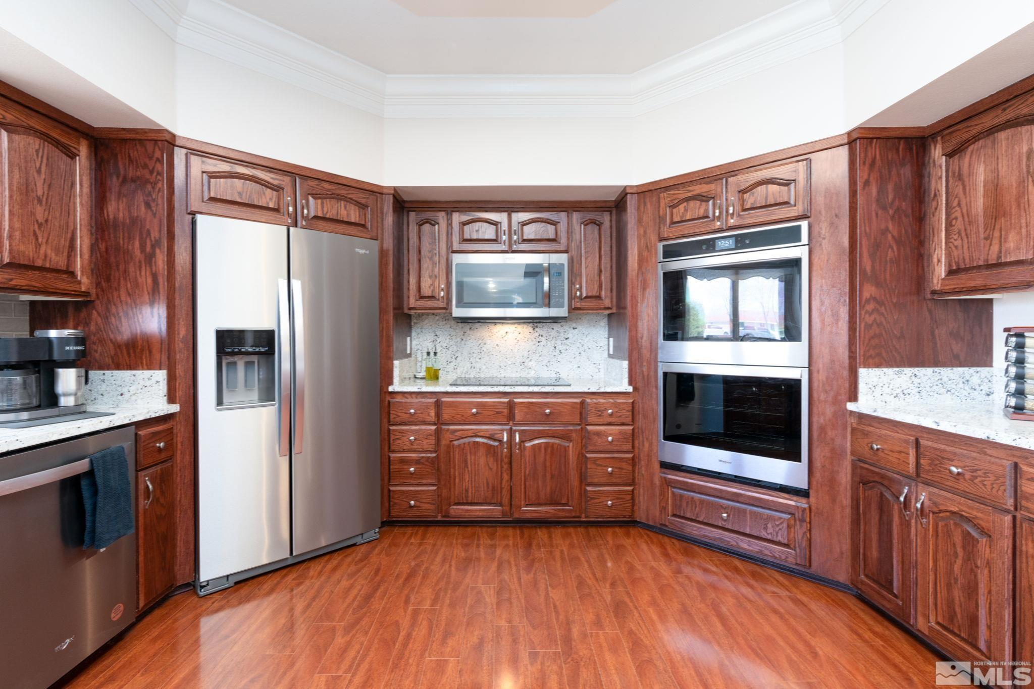 615 Carson River Drive Fallon, NV 89406 - Photo 14 of 40 a kitchen with stainless steel appliances granite countertop a refrigerator a stove and wooden cabinets