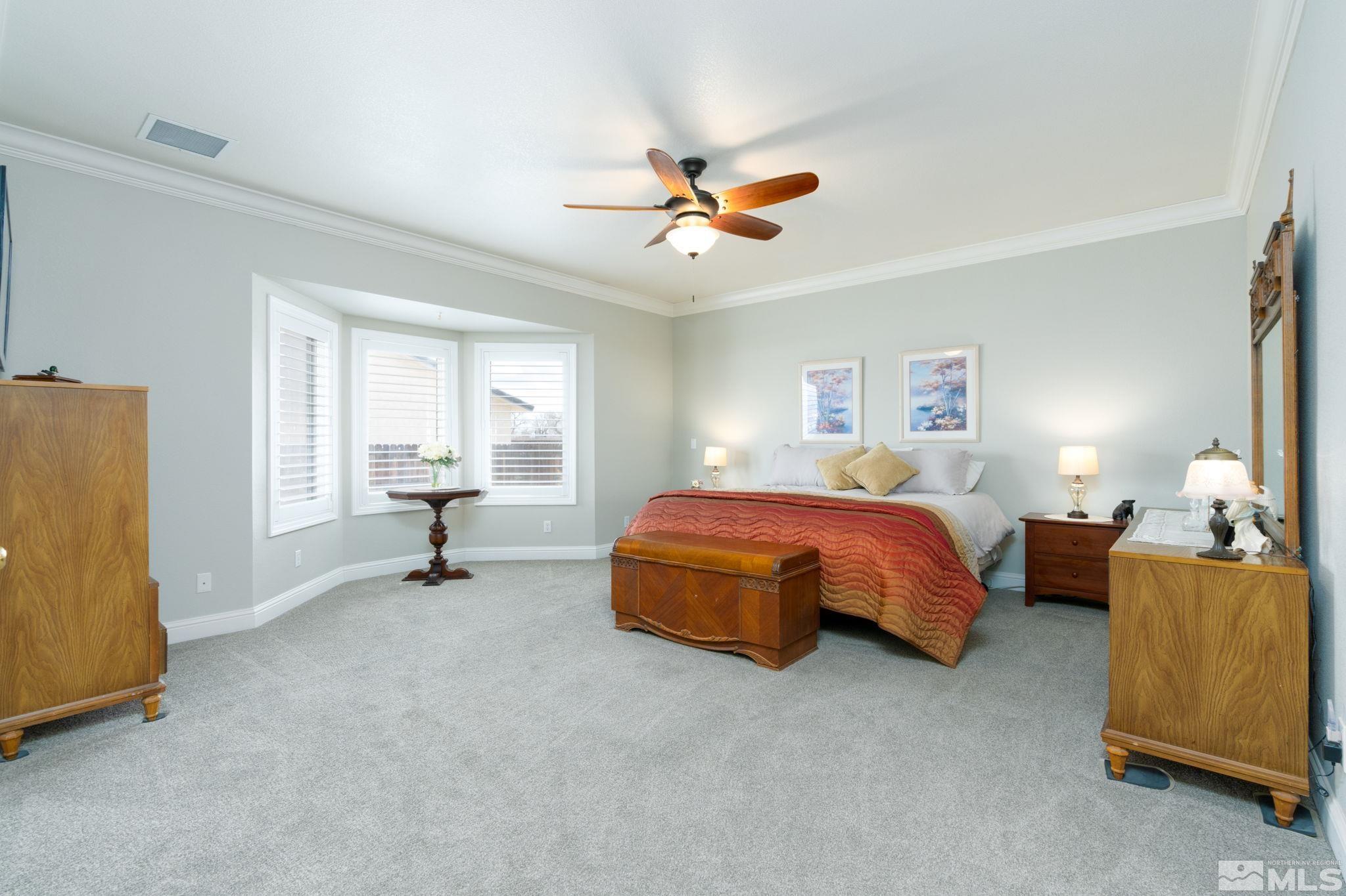 615 Carson River Drive Fallon, NV 89406 - Photo 19 of 40 a spacious bedroom with a bed and a chandelier