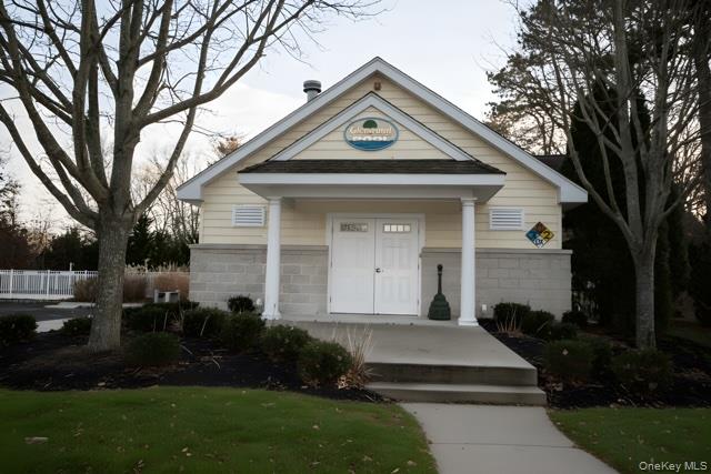1661-519 Old Country Road, Unit 519 Riverhead, NY 11901 - Photo 15 of 17 a front view of a house with a yard