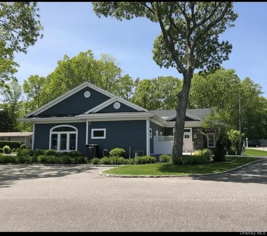 a front view of a house with a yard and trees