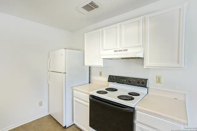 a kitchen with a stove and a refrigerator