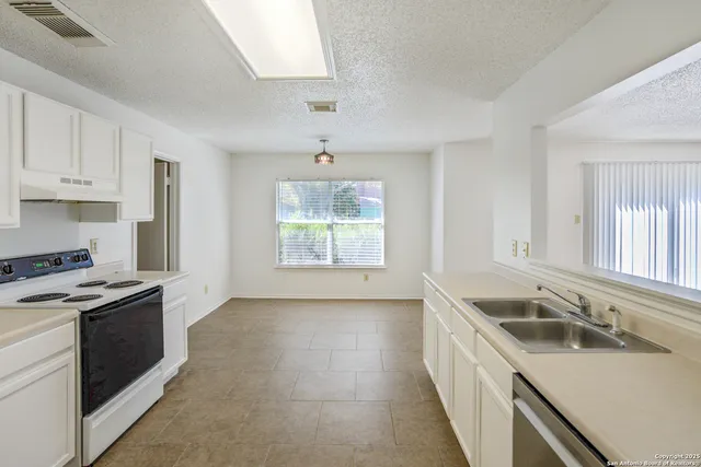 a kitchen with granite countertop stainless steel appliances a stove sink and microwave