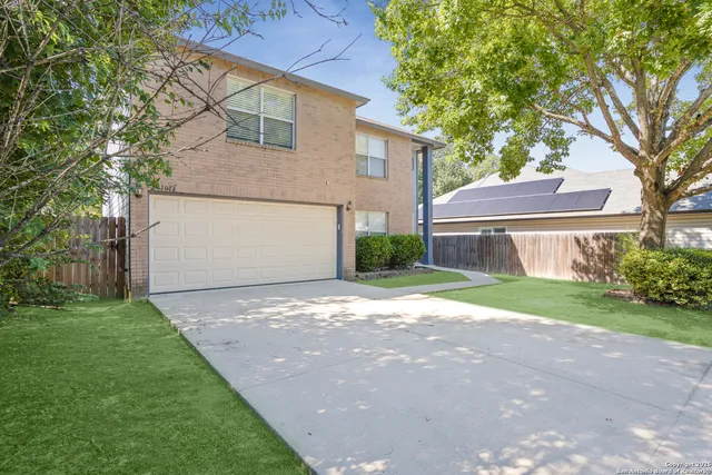 a front view of a house with a yard and a garage