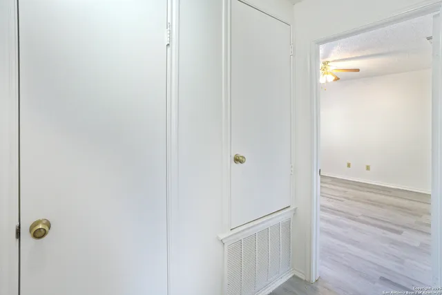 an empty room with a window and a fan