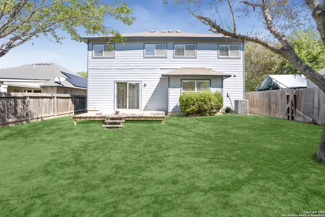 a view of a house with a yard and a tree