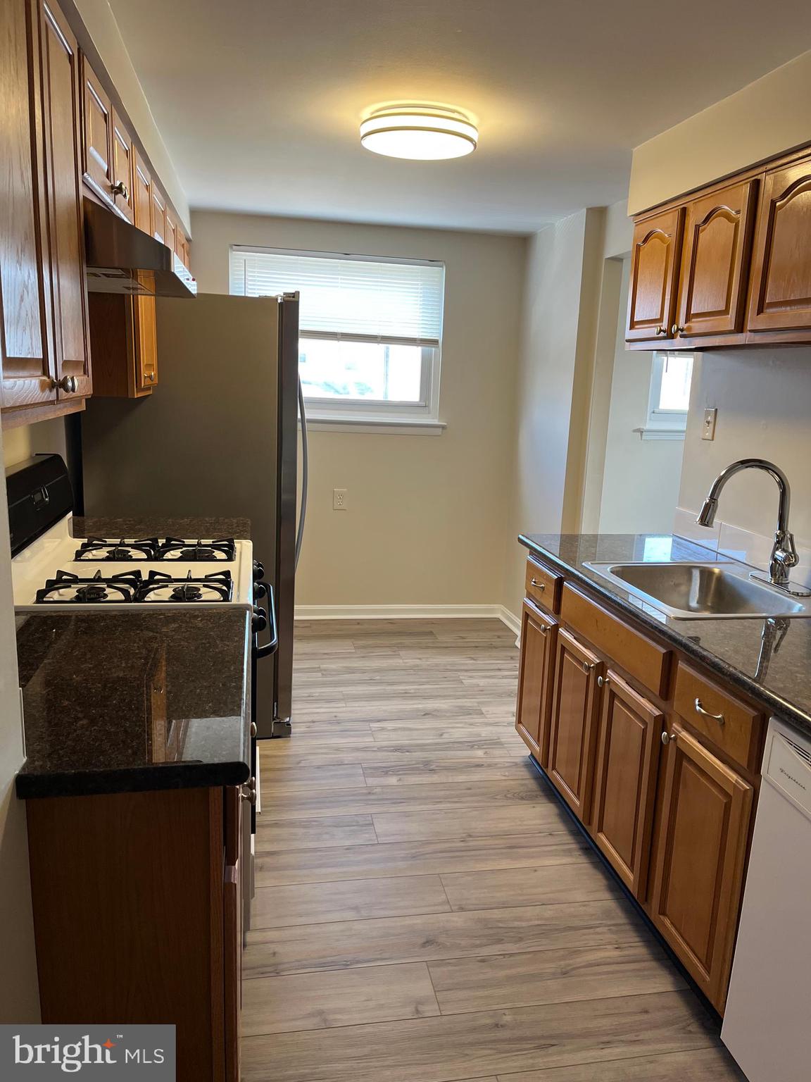 3464 Fitler Street Philadelphia, PA 19114 - Photo 5 of 22 a kitchen with wooden cabinets a stove and a refrigerator