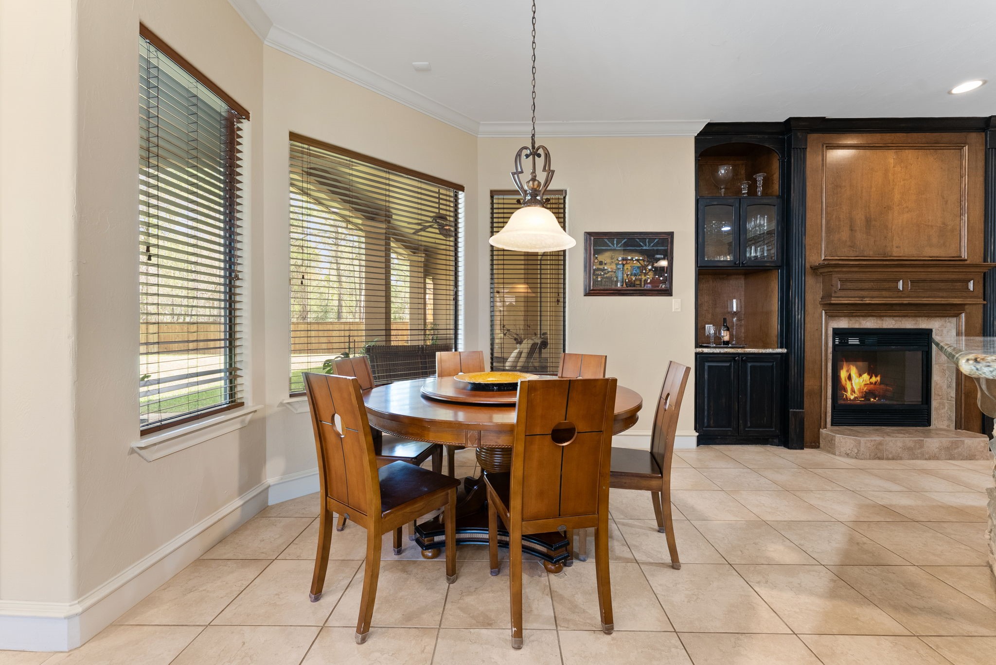 3907 Rayford Road Spring, TX 77386 - Photo 15 of 38 Open to the kitchen and family room, the breakfast area is filled with natural light from large windows overlooking the pool, with crown molding and a hanging light fixture adding to the inviting feel.