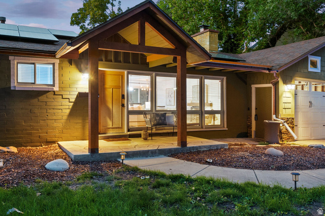 1709 Meadowmoor Road Holladay, UT 84117 - Photo 5 of 32 Covered entry with stone-finish patio, wood-finish columns, and a solid wood front door