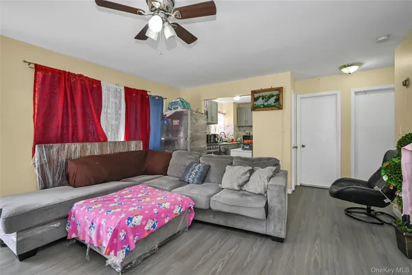 a living room with furniture kitchen view and a window